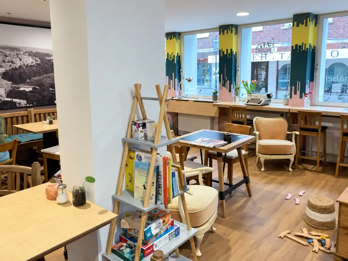 Kleine Spiel-Pyramide mit Büchern, Spielen und Spielsachen zwischen den Sitzplätzen im Café Nebenan in Emden